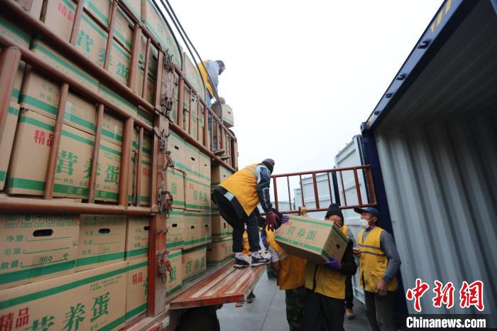 圖為鐵路裝卸作業(yè)人員正在將云南特色農(nóng)產(chǎn)品裝入集裝箱?！詈?攝