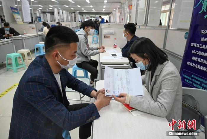 4月14日，招聘者在查看求職者簡歷。<a target='_blank'  data-cke-saved- >中新社</a>記者 王剛 攝