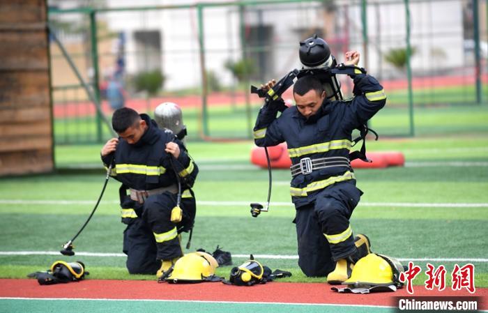 新消防員進行穿戴空呼器展示。　劉忠俊 攝