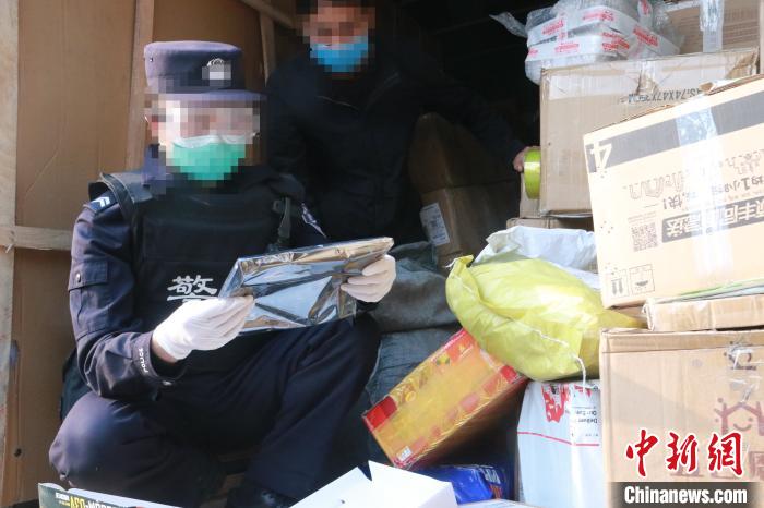 圖為勐康邊檢站民警在對(duì)快遞運(yùn)輸車輛進(jìn)行例行檢查?！钐?攝