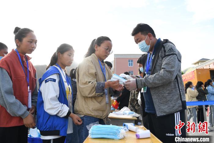 7月7日，考生在拉薩三高考點(diǎn)外領(lǐng)取口罩?！『闻罾?攝