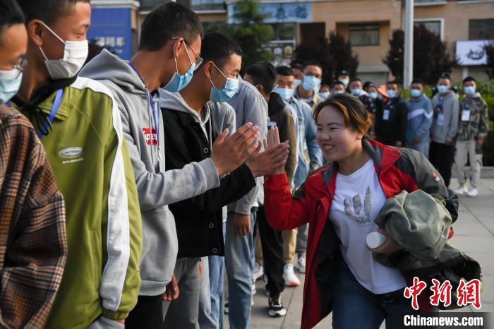 7月7日，拉薩三高考點(diǎn)外，領(lǐng)隊(duì)老師與考生擊掌鼓勁加油?！『闻罾?攝