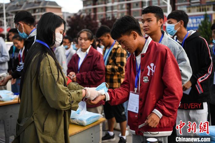 7月7日，考生在拉薩三高考點(diǎn)外測量體溫?！『闻罾?攝