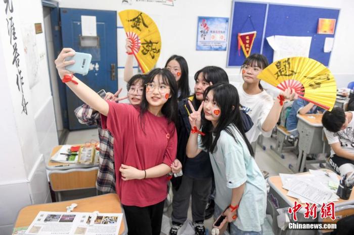 資料圖：6月6日，2021年高考前夕，湖南長(zhǎng)沙同升湖實(shí)驗(yàn)學(xué)校高三年級(jí)，考生們?cè)诮淌覂?nèi)合影。 楊華峰 攝