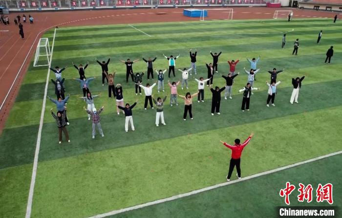 寧夏大學校園內，學生跟隨老師練習八段錦。 謝宇 攝