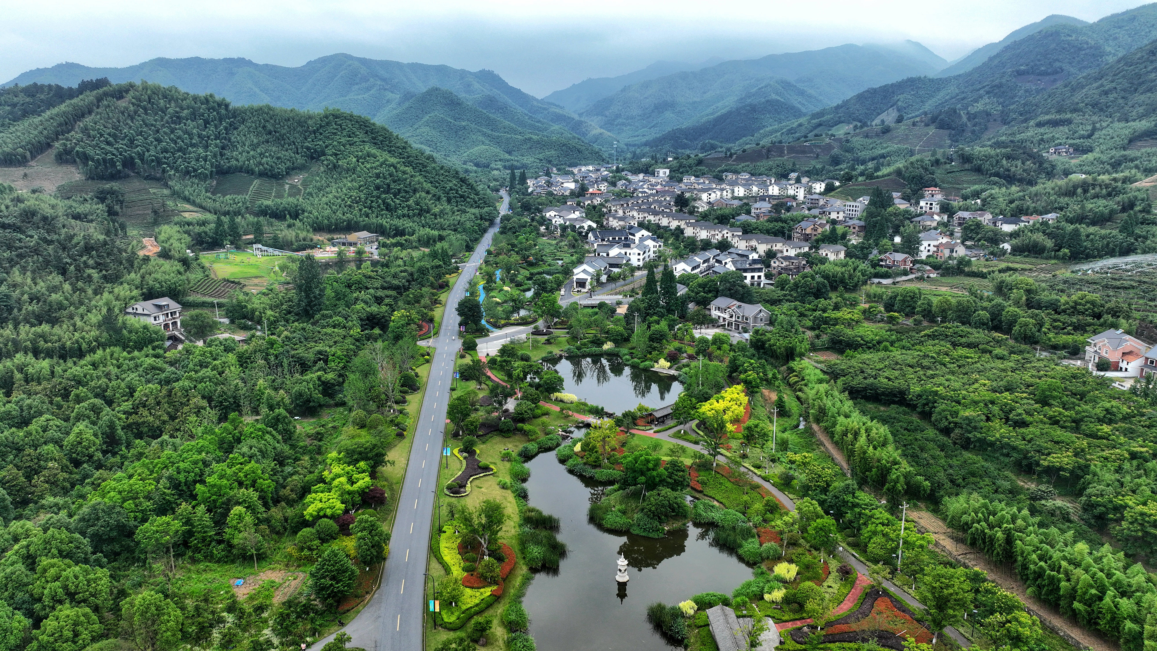 2023年6月6日，杭州余杭區(qū)徑山鎮(zhèn)鄉(xiāng)村，生態(tài)碧水、沿路花海與村莊農(nóng)房相映成趣，構(gòu)成一幅美麗的山水田園畫。