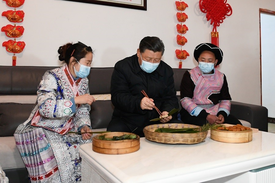 2021年2月3日下午，習(xí)近平在貴州畢節(jié)市黔西縣新仁苗族鄉(xiāng)化屋村苗族村民趙玉學(xué)家，同一家人邊聊家常邊制作當(dāng)?shù)貍鹘y(tǒng)節(jié)日食品黃粑。新華社記者 李學(xué)仁 攝