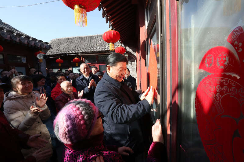 2019年2月1日上午，習(xí)近平在北京前門東區(qū)草廠四條胡同32號院，高興地拿起一幅“?！弊郑H自貼到門上，給這里的老街坊們拜年。新華社記者 鞠鵬 攝